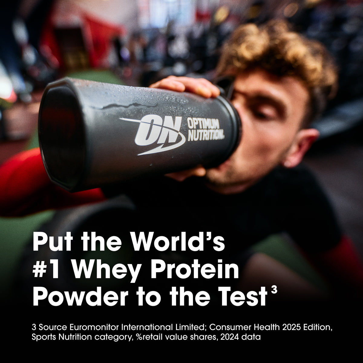 Person drinking from a Optimum Nutrition protein shaker in a gym setting